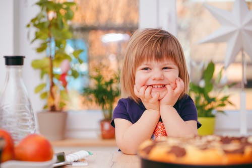 Smiling child with hands on face