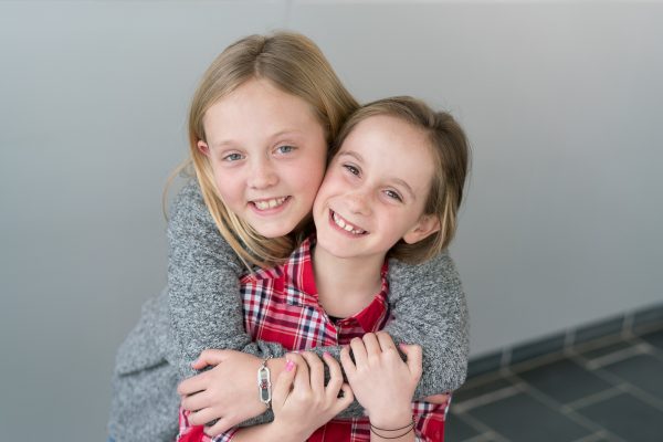 Two little girls hugging and smiling